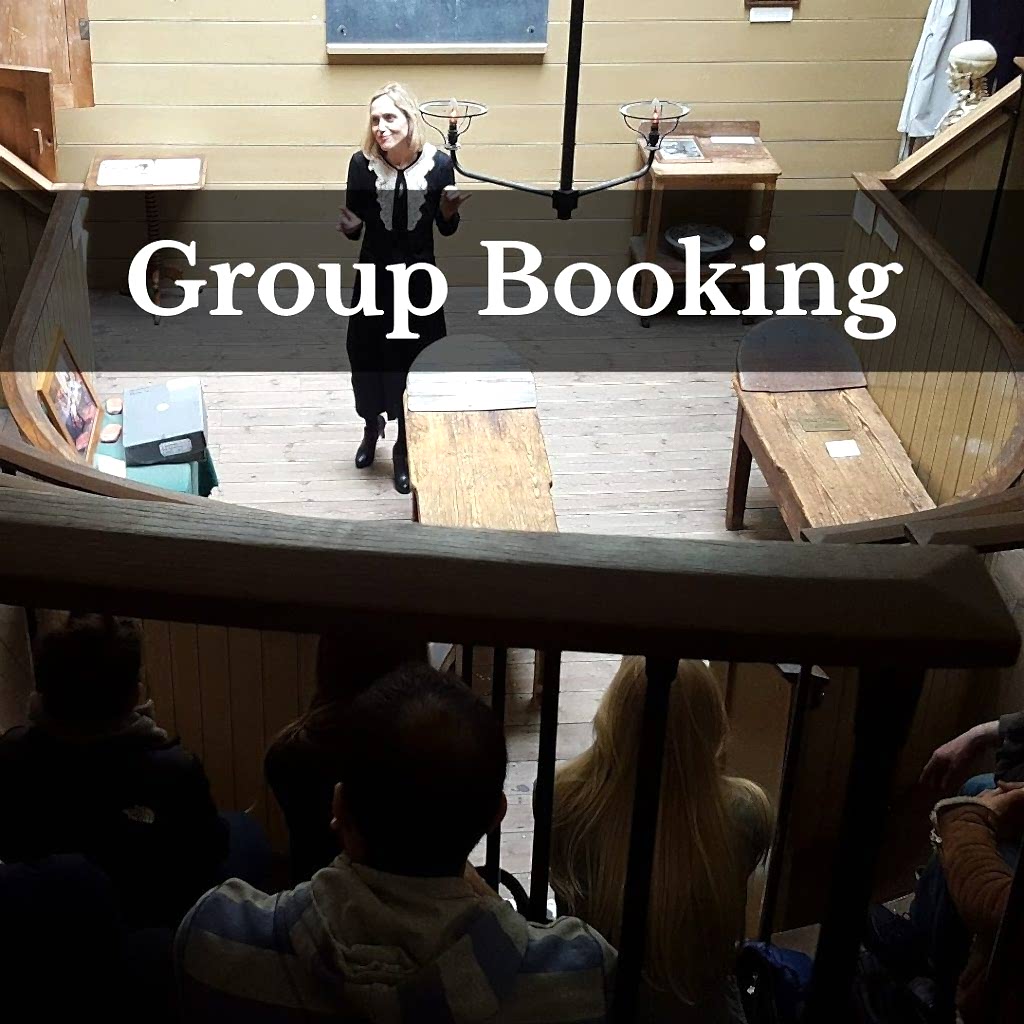 Woman presenting within old operating theatre; text says Group Booking
